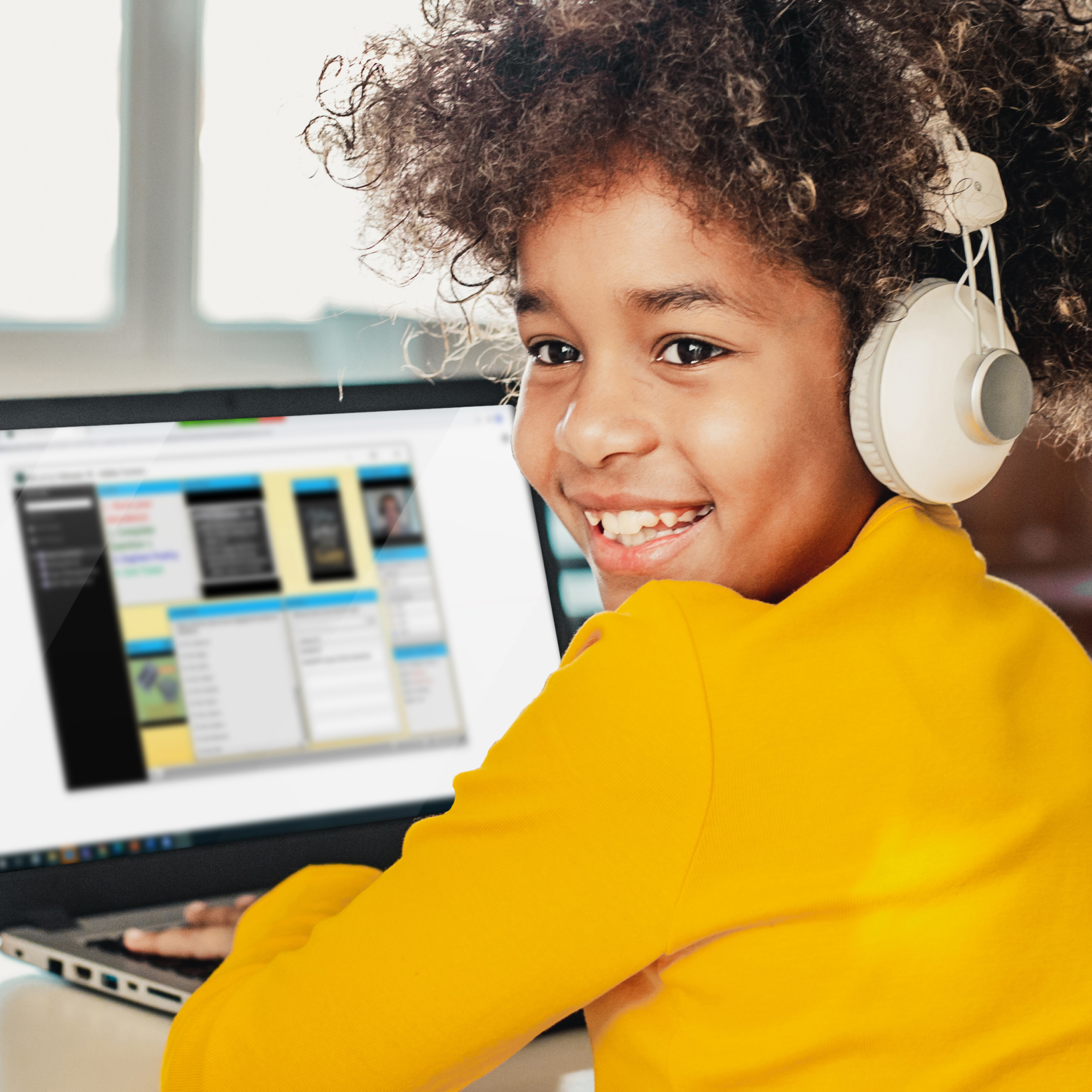 A young girl is smiling while listening to an online lesson