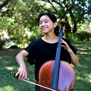 Image of Fiona Tsang, a cellist, National Merit Finalist, and senior at Ohio Connections Academy. She is wearing a black shirt and playing her cello.