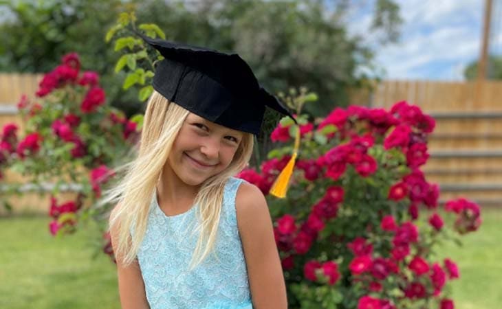 Image of Aria from Willamette Connections Academy in front of a red rose bush.