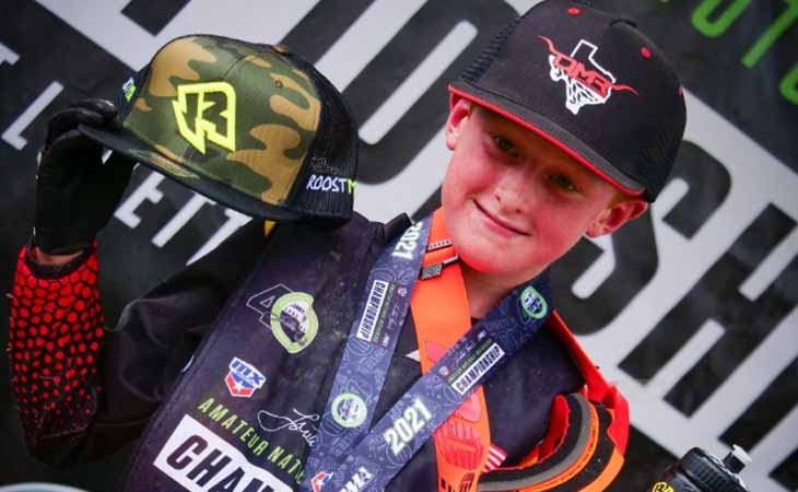Image of BMX biker Jackson from Texas Connections Academy showing off his awards. 