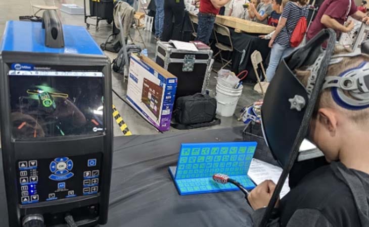 Emmett from from Utah Connections Academy working on coding a game at a tech expo. 
