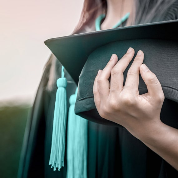 Caucasian female holding a graduation cap - Connections Academy