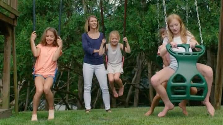Mother pushing her three children on a swingset - Reach Cyber Charter School