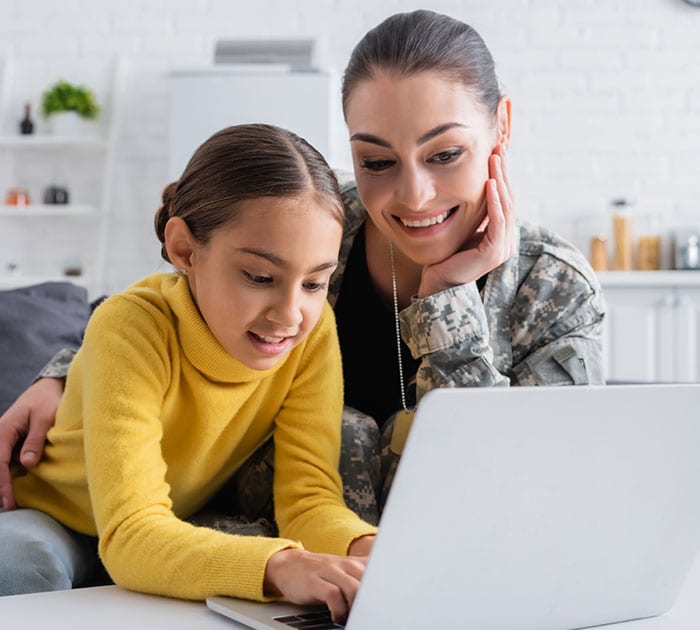 A miltary parent and daughter looking at a laptop together - Connections Academy