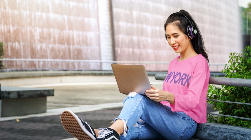 Asian female high school student prepares college application on laptop  - Connections Academy