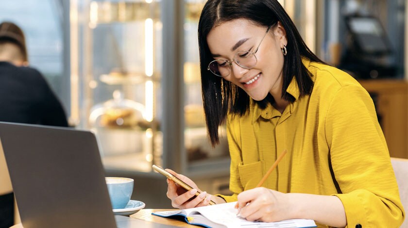 A career-focused student writing in a notebook - Connections Academy