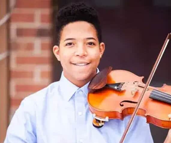 Leon middle school student and concert violinist smiling at camera