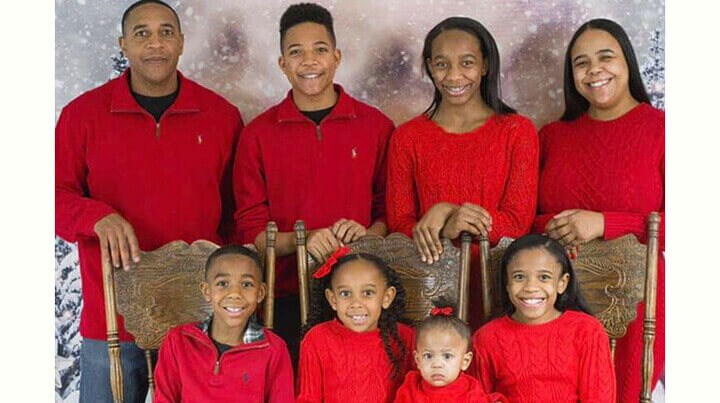 Image of Leon with his family in red shirts