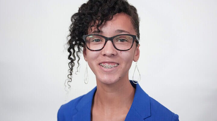 A headshot of Madison smiling