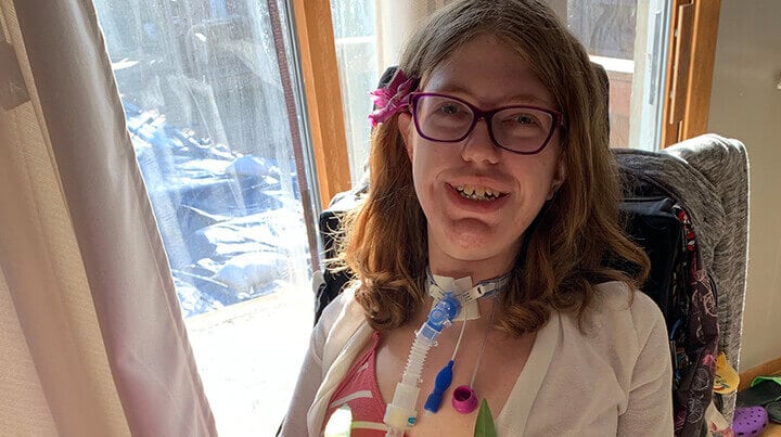 Sarah sitting next to a window smiling