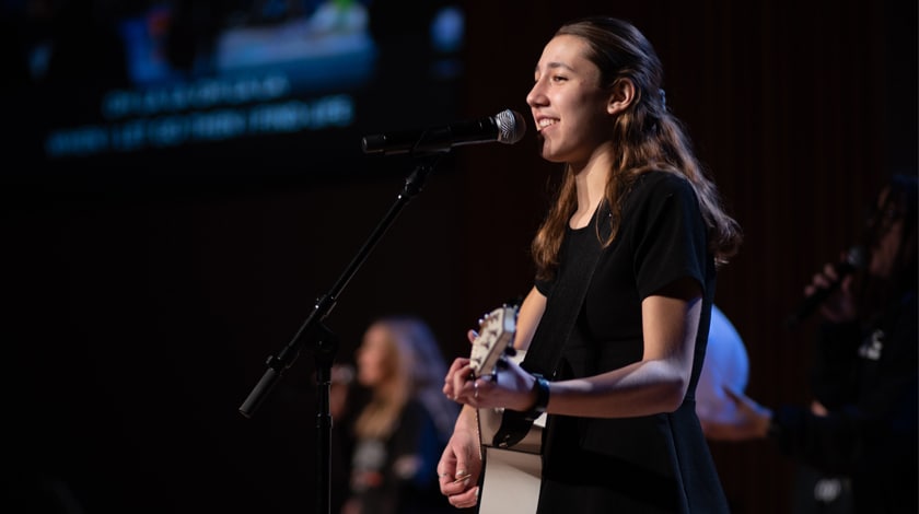 Maddie playing guitar on stage