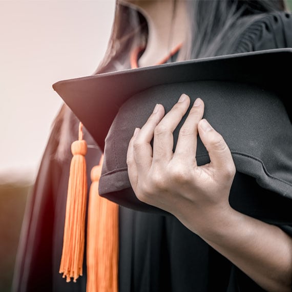 Caucasian female holding a graduation cap - Connections Academy