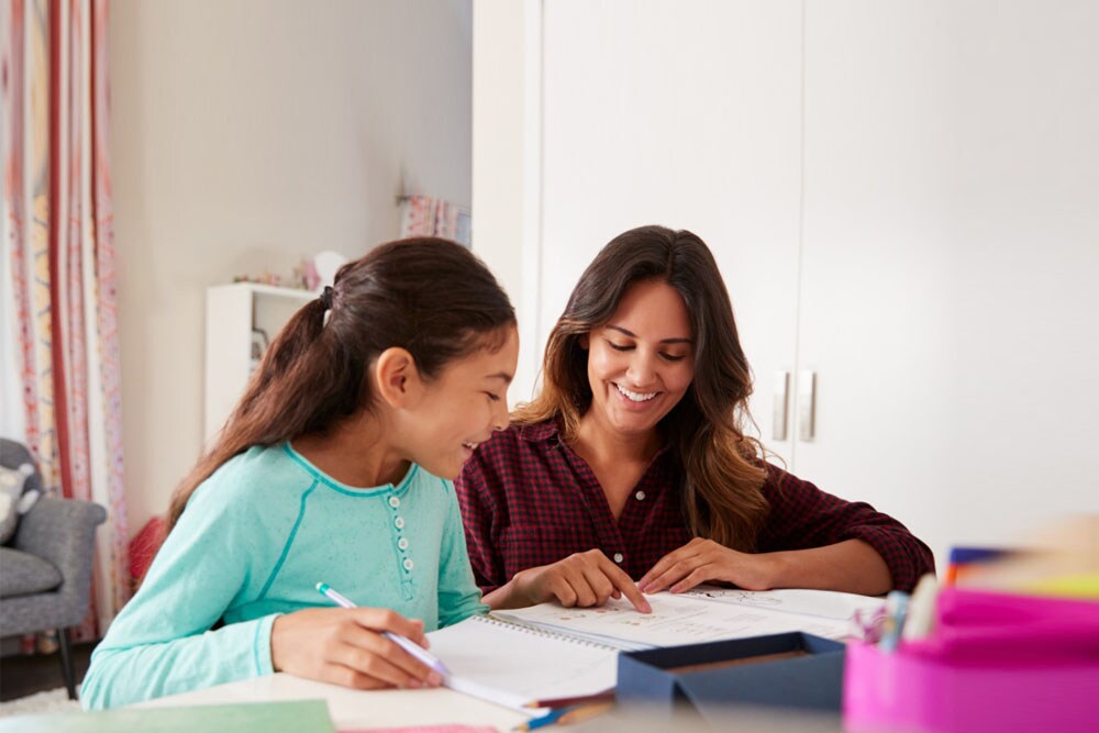 Young girl in aqua blue working with her Learnig Partner in an online class.