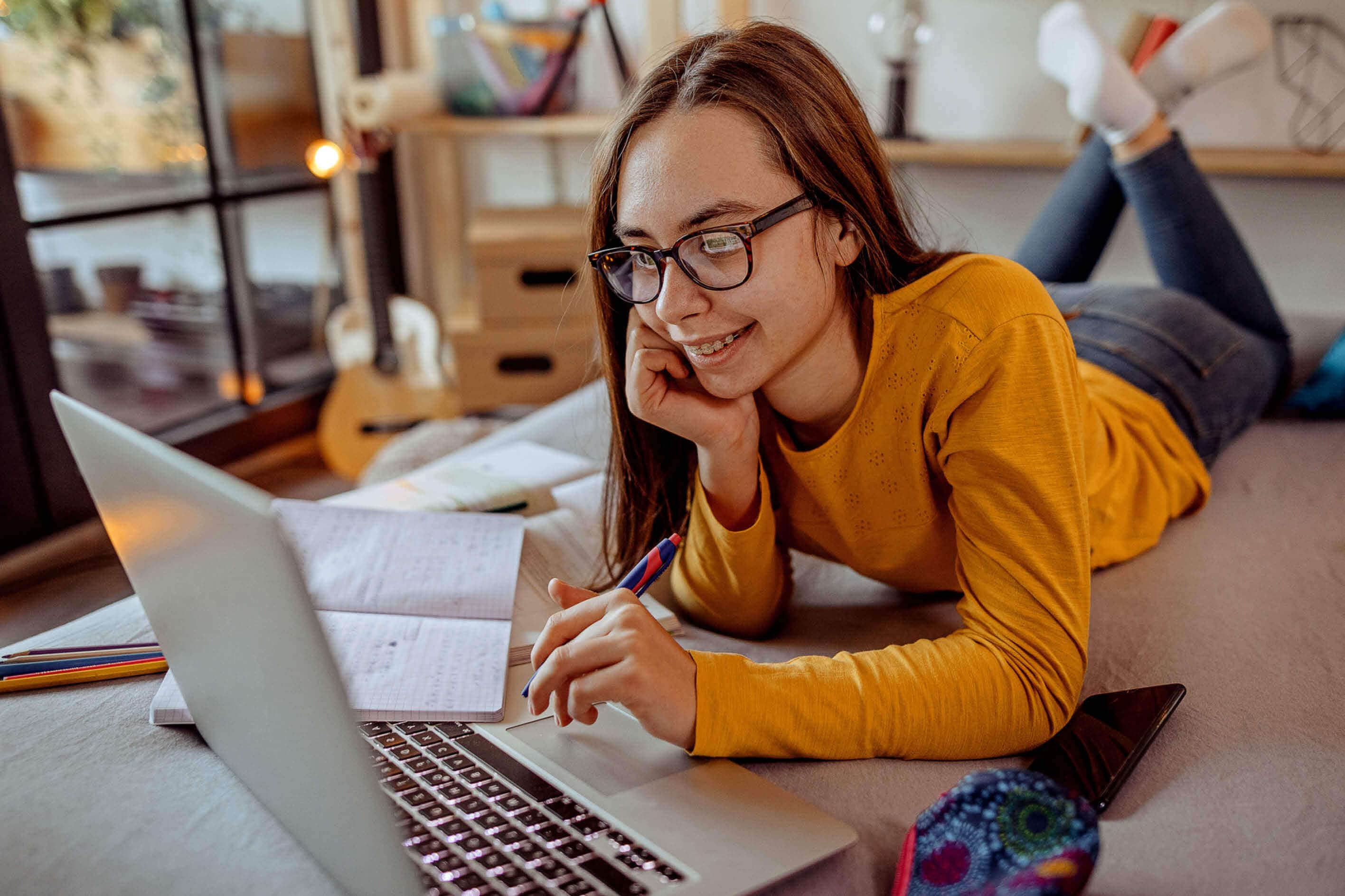 Young girl attending online school on her laptop