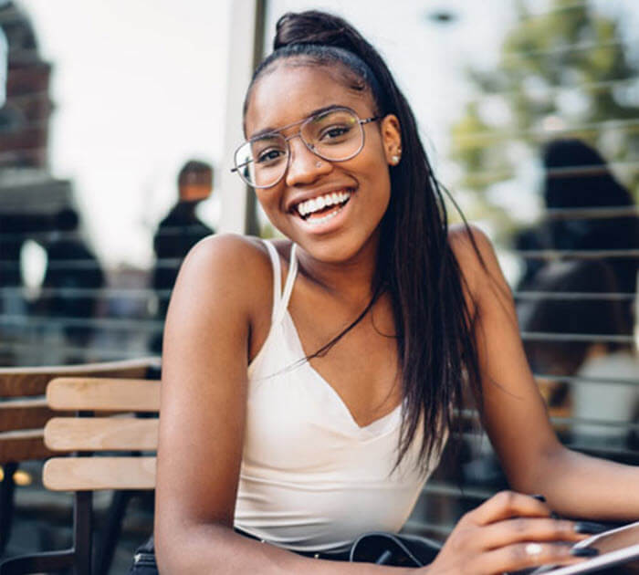 Teenage student holding a tablet and smiling 