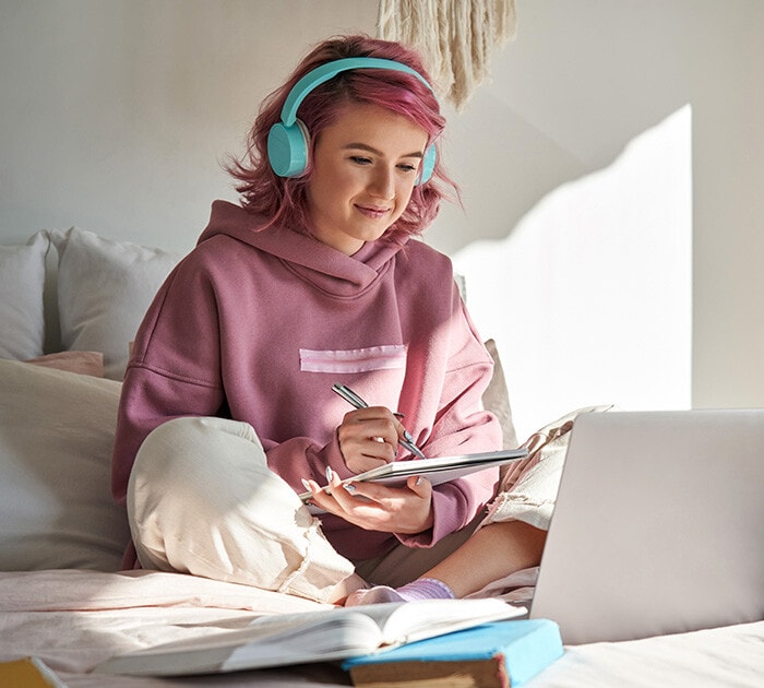 Young student writting in a notepad - Connections Academy