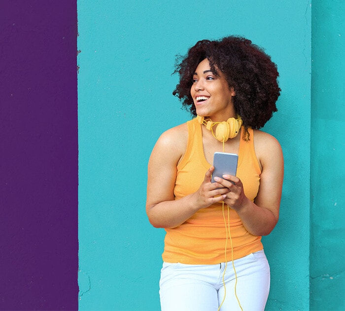 A Connections Academy student standing holding a phone.