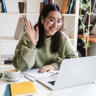 Girl waving at a friend on a laptop computer - Connections Academy