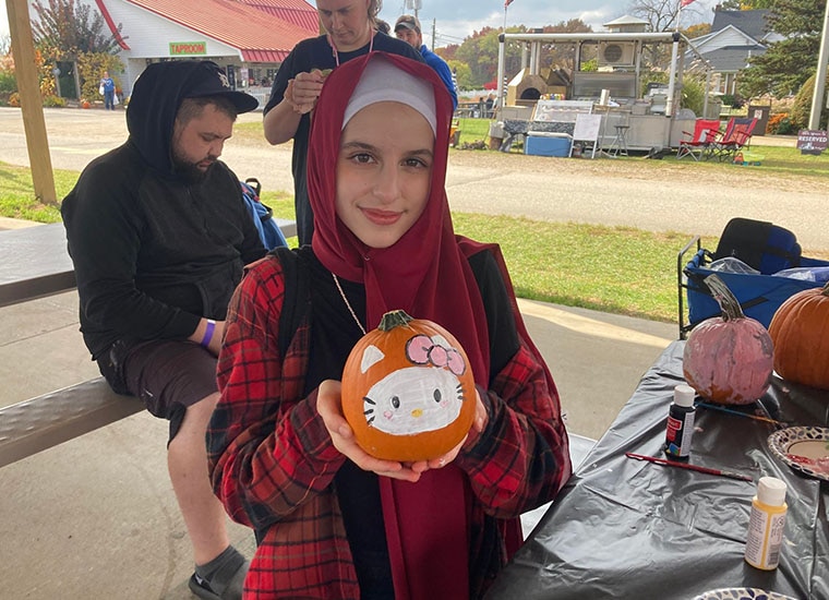 A student holds a Hello Kitty themed pumpkin