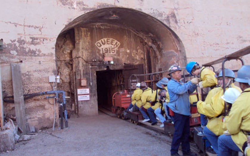 Students boarding a train to take a ride into a mine