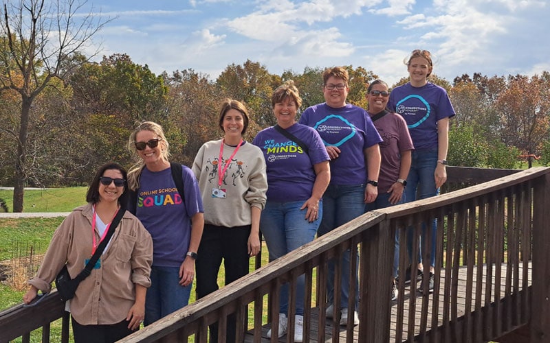 Missouri Connections Academy staff gathered on a bridge smiling
