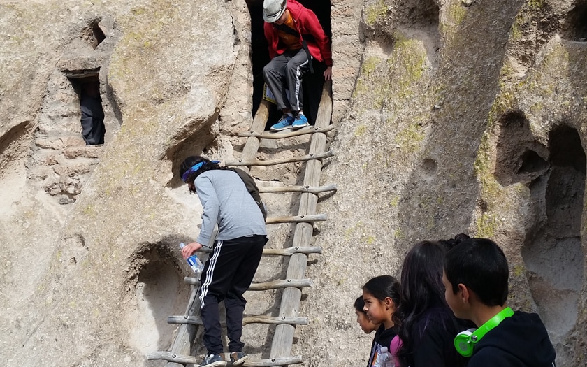 Visiting the Bandelier National Monument, students climbing the pueblo stairs. 