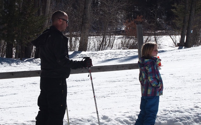 One student and a teacher posing on the ski slope