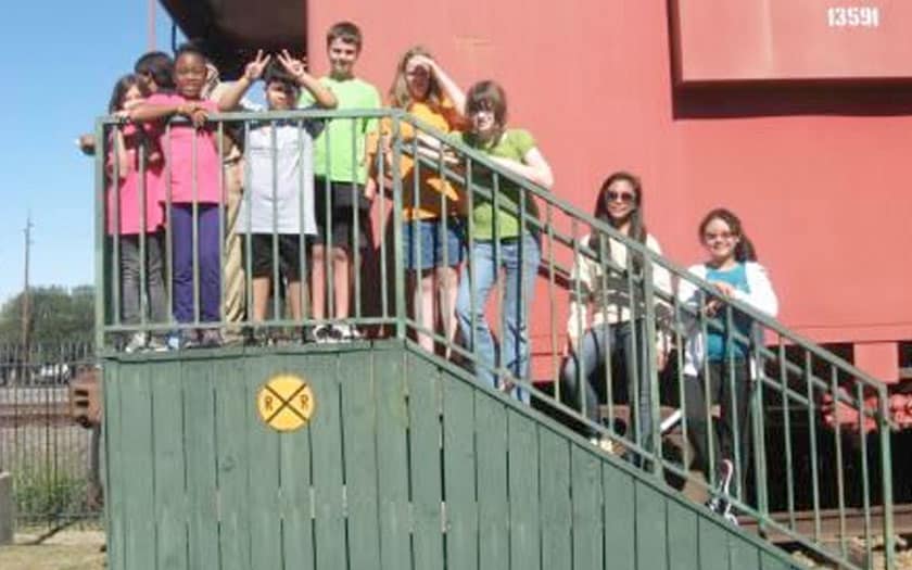 Students are standing on the steps of a railroad station