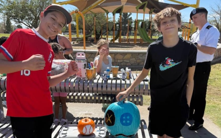 Two students pose with their newly painted pumpkins