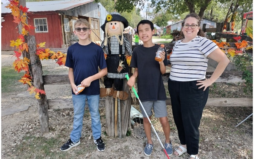 A group of students standing in front a scarecrow