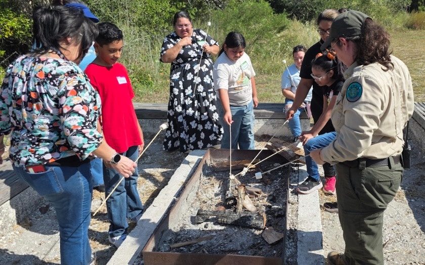 Students roast marshmellow over a fire