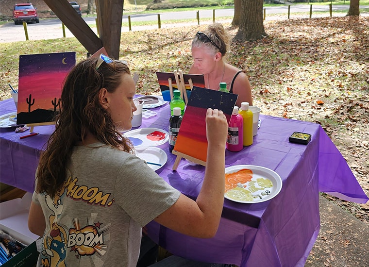 Two students painting in the park