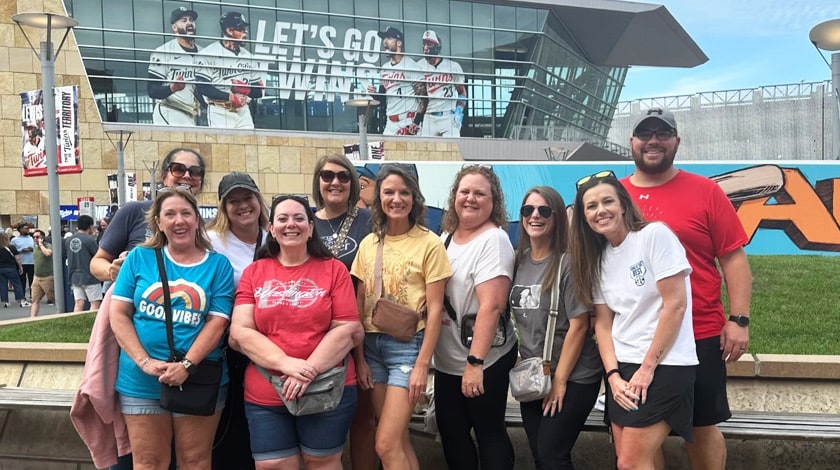 Staff gathered together at a baseball game