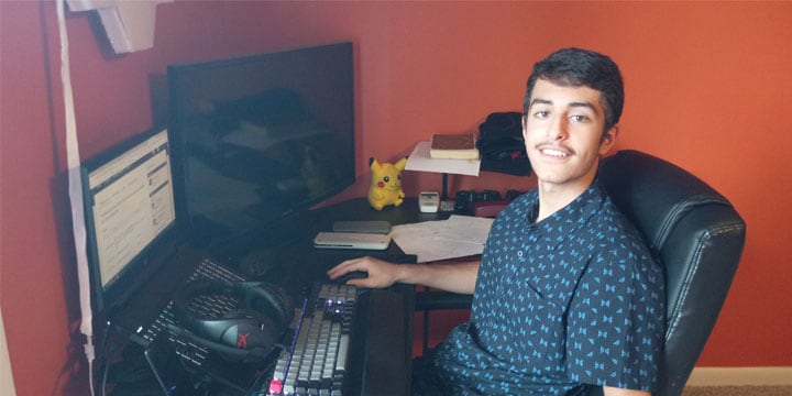 Humam sitting at his desk