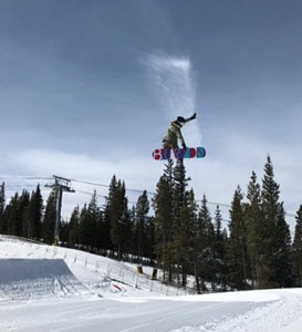 Kayleigh jumping on a snowboard