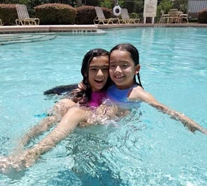 Charlotte and her sister Shelby in a swimming pool