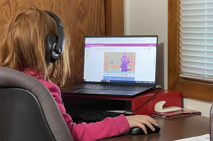 Payton sitting at her desk and attending online school