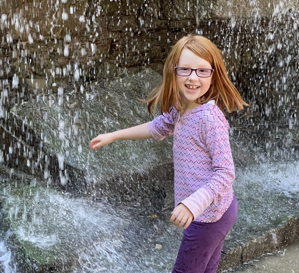 Payton smiling in front of a waterfall