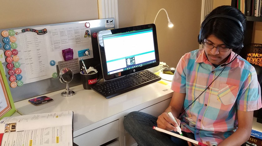 Abrar at his desk attending online school