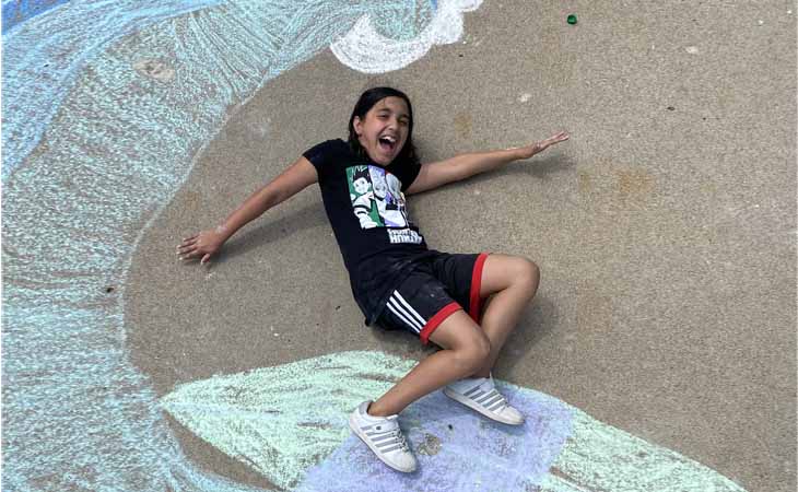 Ava, a student at Lighthouse Connections Academy riding a chalk wave!