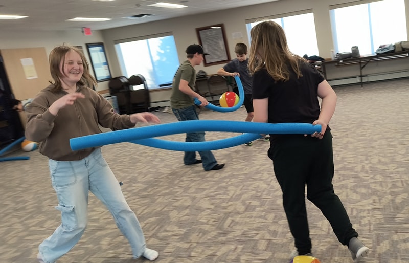 Evy and another student engaging in a fun activity on a field trip