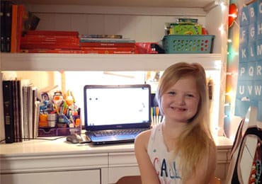 Evy smiling and sitting at her desk