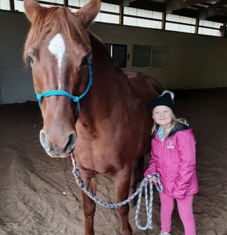 Evy standing next to a horse