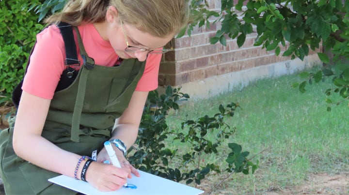 Olivia drawing in a notebook