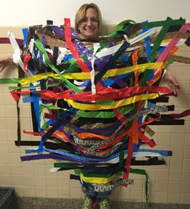 Tracey taped to a wall with colorful tape at a school event