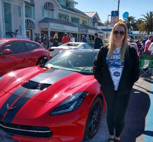 Kylie with a red sports car