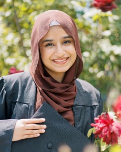 Aroosh smiling holding her graduation cap