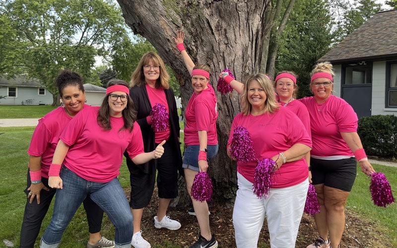 A group of Wisconsin Connections Academy staff posing together in front of a tree