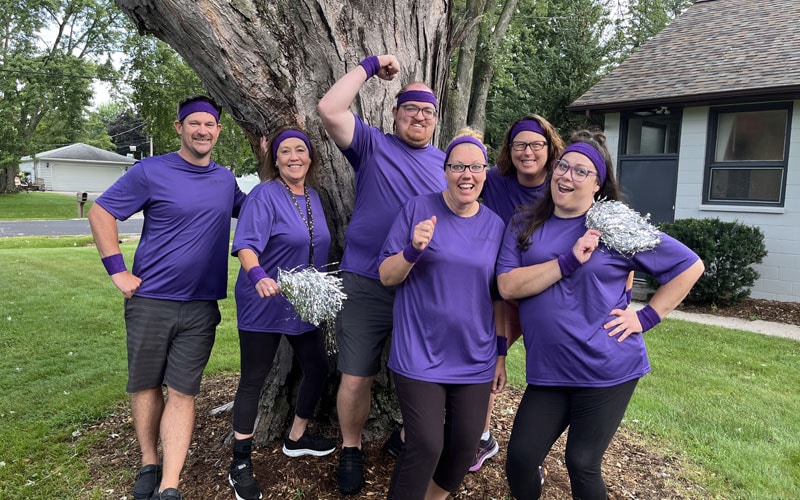 A group of Wisconsin Connections Academy staff posing together in front of a tree