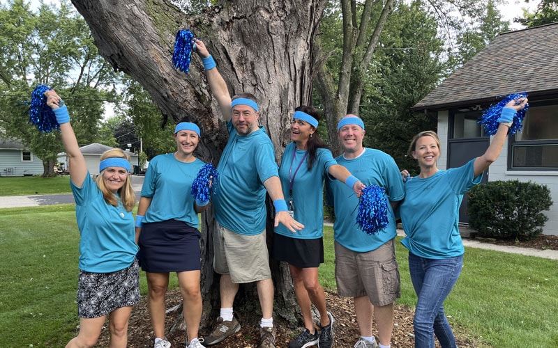 A group of Wisconsin Connections Academy staff posing together in front of a tree